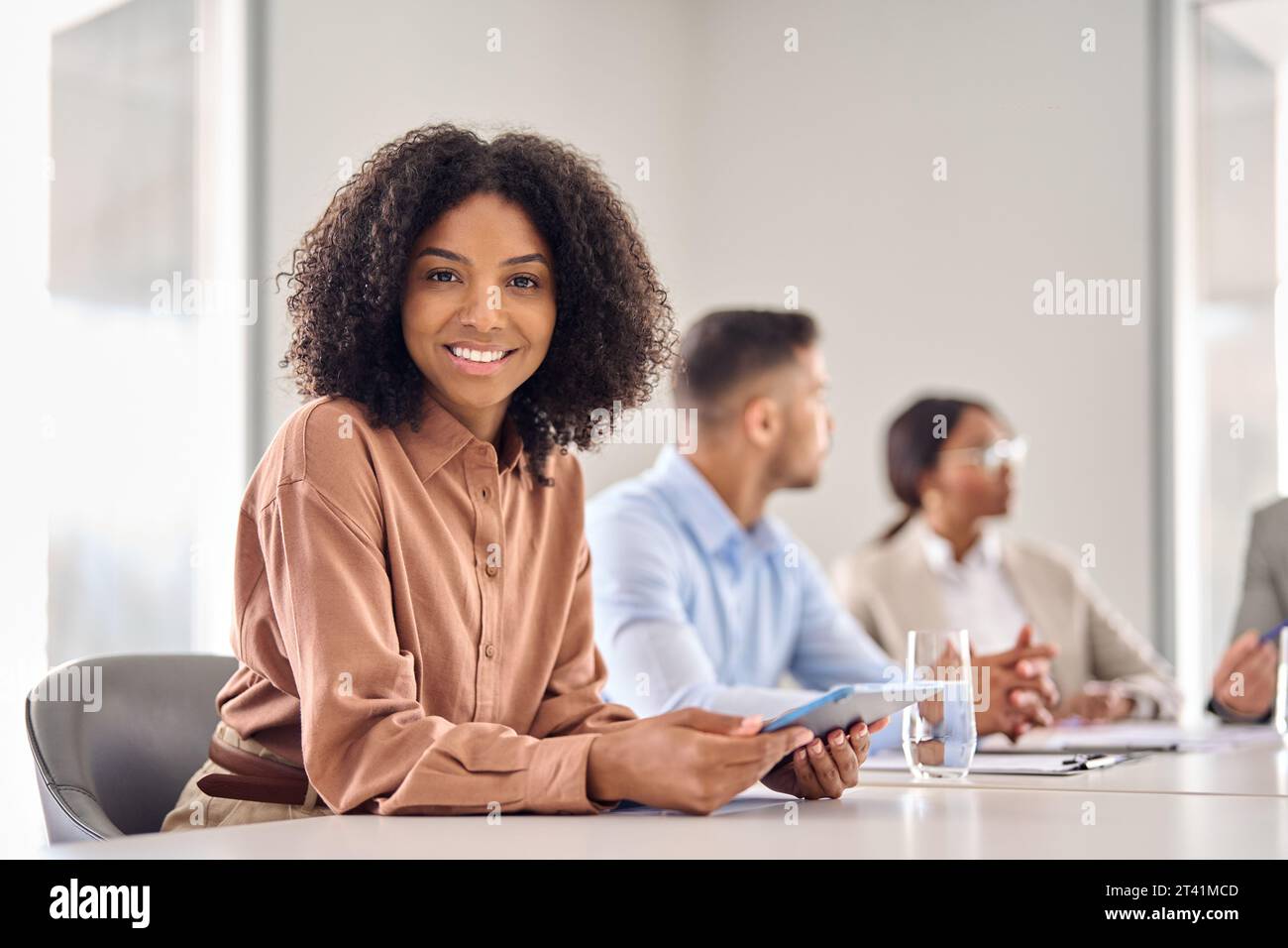 Smiling young African American business woman at office meeting, portrait. Stock Photo