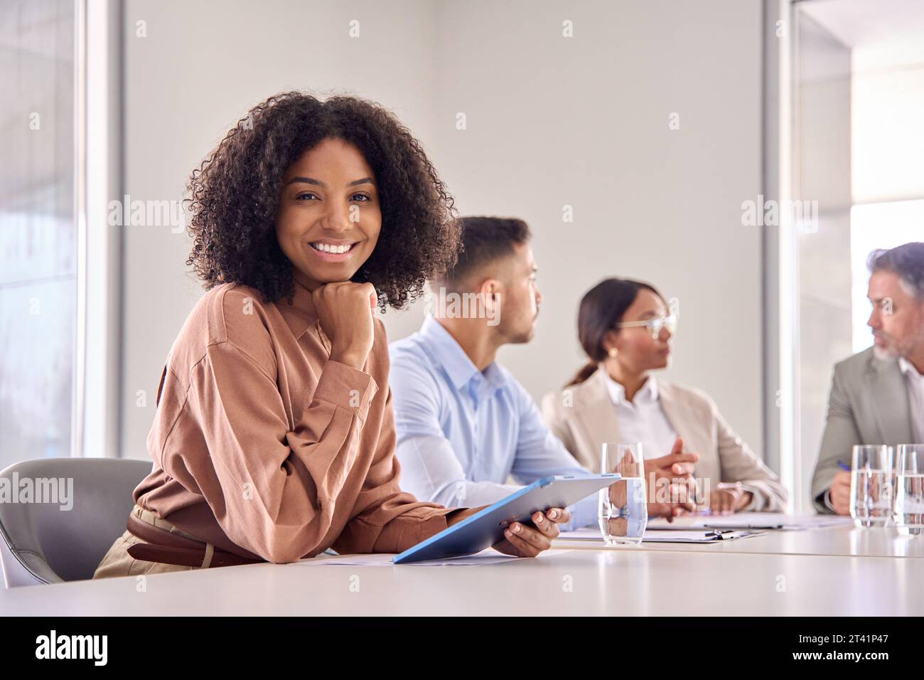 Portrait of happy young African American business woman at office meeting. Stock Photo
