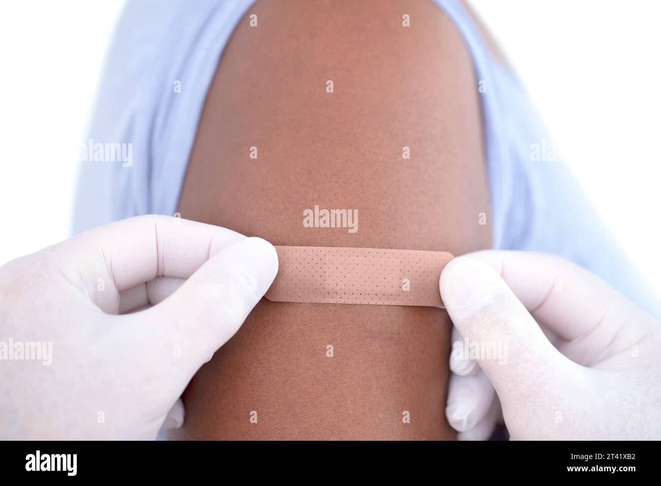 Plaster being applied to woman's arm Stock Photo