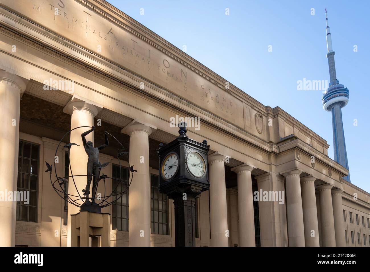 Statue and clock at Union Station plaza with CN tower in the background. Toronto, ON, Canada Stock Photo