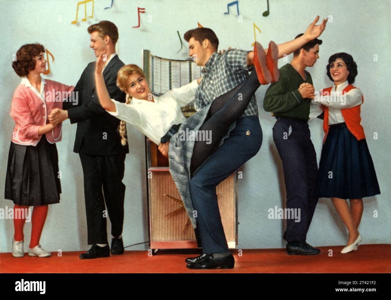 1958 ca,  WEST GERMANY : German postcard in real taste of FITIES YEARS , with TEENAGERS dressed in modern taste of ROCK'N ROLL HAPPY DAYS AGE , they dance acrobatic around a juke box . Unknown photographer . - HISTORY - FOTO STORICHE - TEENAGERS - MODA AMERICANA - AMERICAN FASHION - ANNI CINQANTA - 50's - '50 -  1950's - DESIGN - POP - JUKE-BOX - donna - woman  - ragazze - ragazzi - BOYS - YOUNG GIRLS - WOMEN - PANTALONE -  STILE - STYLE - blonde - summer  jamboree  - MUSICA - MUSIC - MODERNO - MODERN - ROCK'A BILLY - DANCE - DANZA ACROBATICA - BALLO - DANCING - PARTY - FESTA - alle Stock Photo