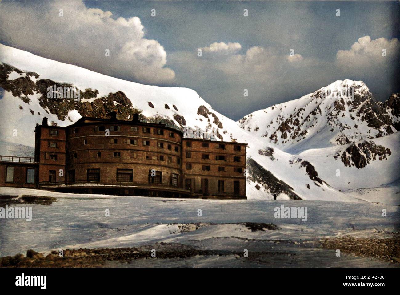 1950 c., CAMPO IMPERATORE , GRAN SASSO D'ITALIA , L'AQUILA, ABRUZZO , ITALY : The italian Fascist Duce BENITO MUSSOLINI was in prisony in Albergo Campo Imperatore ( Gran Sasso d'Italia , Abruzzo ) . In the day 12 semptember 1943 ) was saved by german militaries on order by ADOLF HITLER . It was built in the 1930s based on a design by the Piedmontese engineer Vittorio Bonadè Bottino , who in the same years designed the hotel structures in Sestriere and the Principi di Piemonte hotel in Turin . Unknown photographer . DIGITALLY COLORIZED . - HISTORY - FOTO STORICHE - GEOGRAPHY - GEOGRAFIA - MONTA Stock Photo