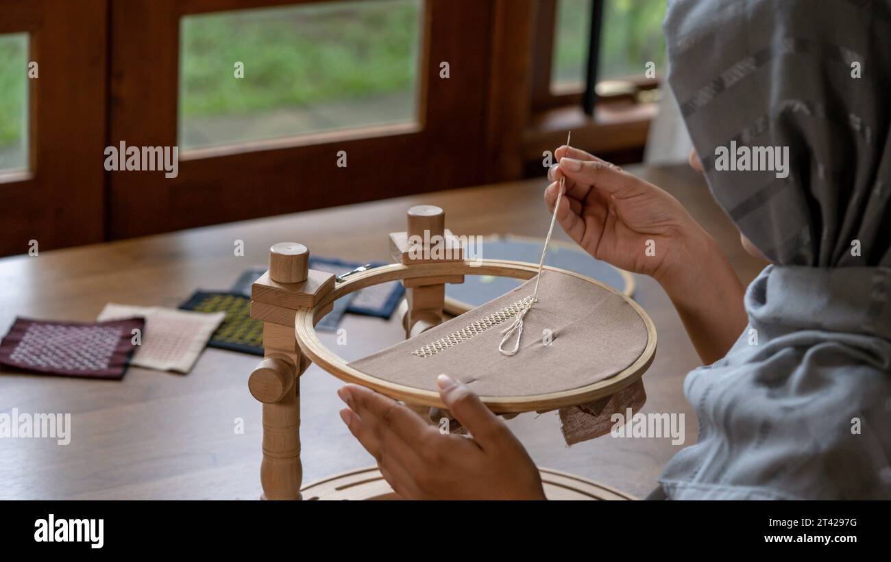 Artistry Unveiled: Women's Hand Stitching Border Pattern on Linen Fabric Stock Photo