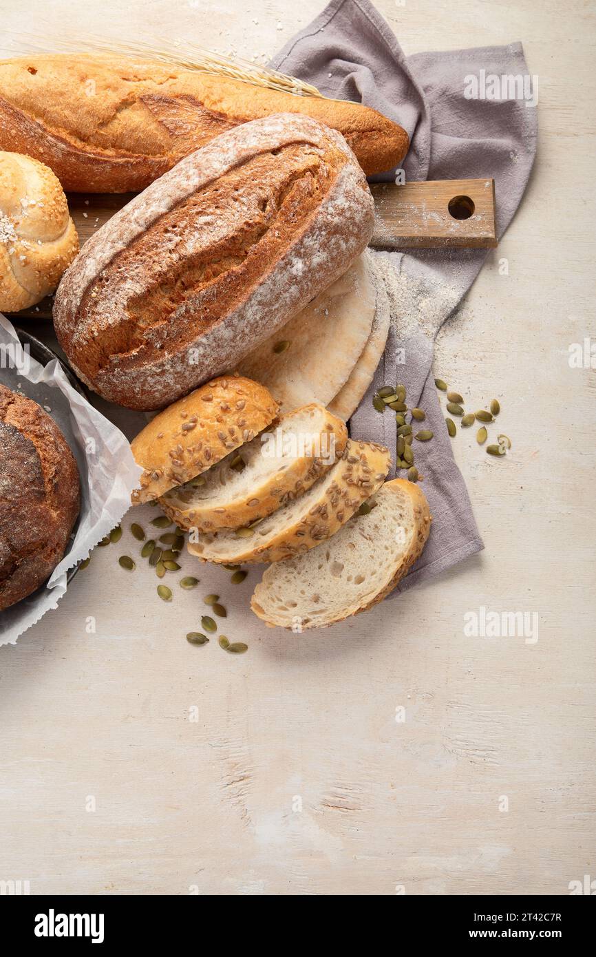 Assortment of various delicious freshly baked bread on white background, top view. Stock Photo