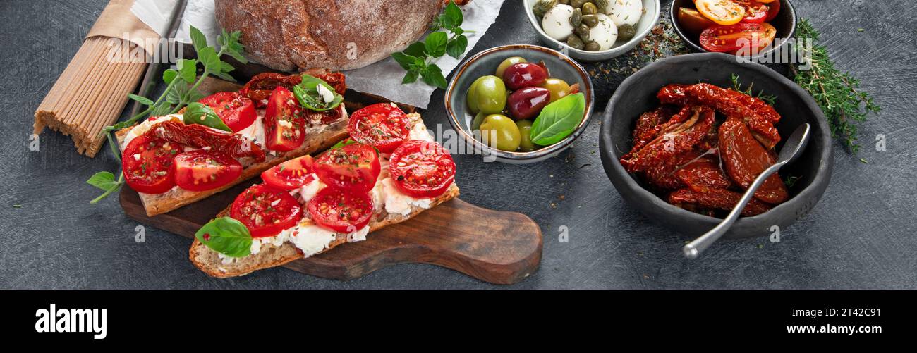 Italian antipasti snacks set. Tasty bruschettas with cheese, sun-dried tomatoes. Traditional food concept. Stock Photo