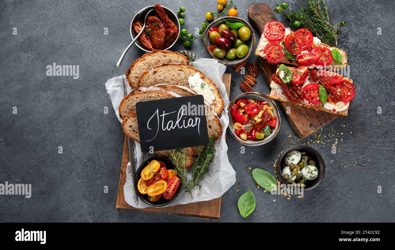 Italian antipasti snacks set. Tasty bruschettas with cheese, sun-dried tomatoes. Traditional food concept. Top view, copy space. Stock Photo