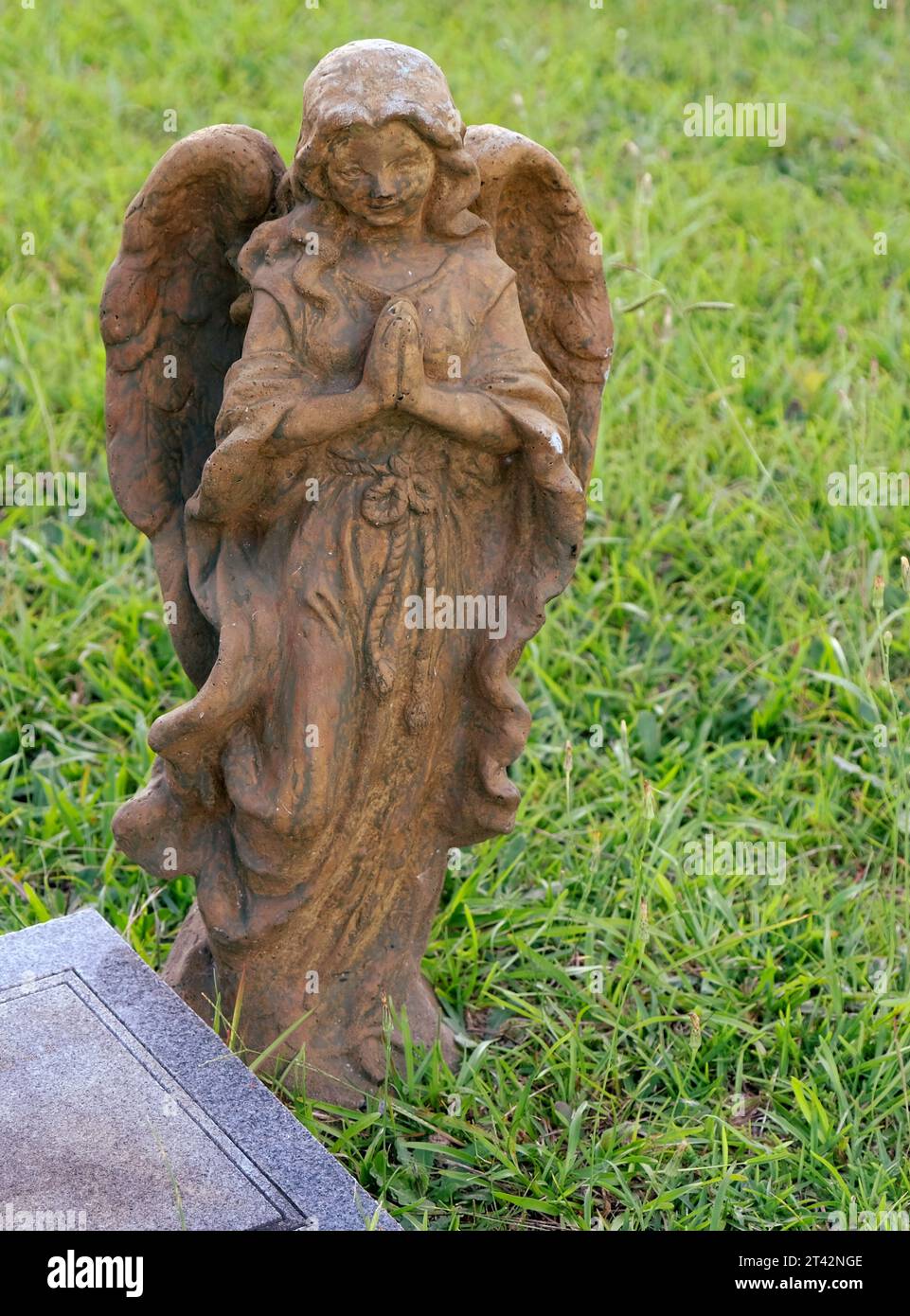 A white marble statue of a cherublike figure with wings standing on a