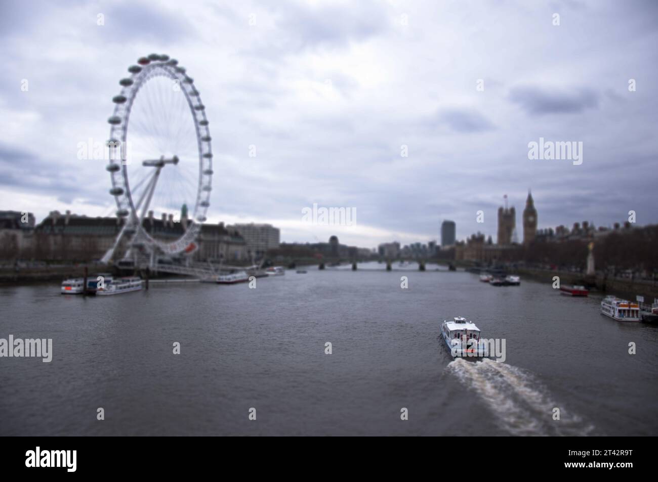 London Eye from Westminster Bridge over River Thames with Houses of Parliament and Big Ben in London, and a boat, UK. Stock Photo