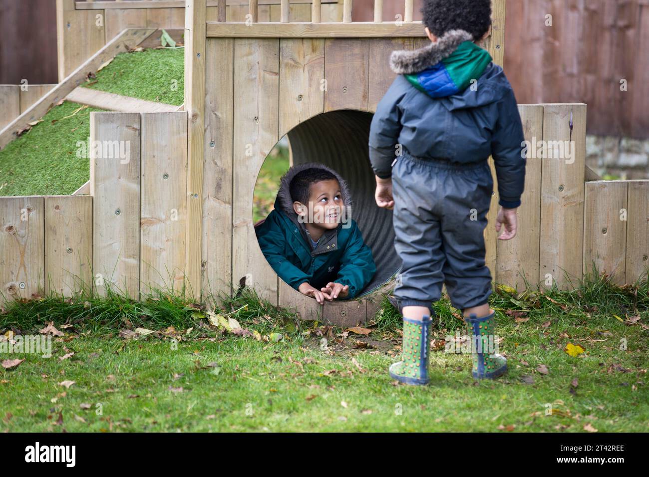 Two Afro-Caribbean boys playing outside at UK nursery school. Stock Photo