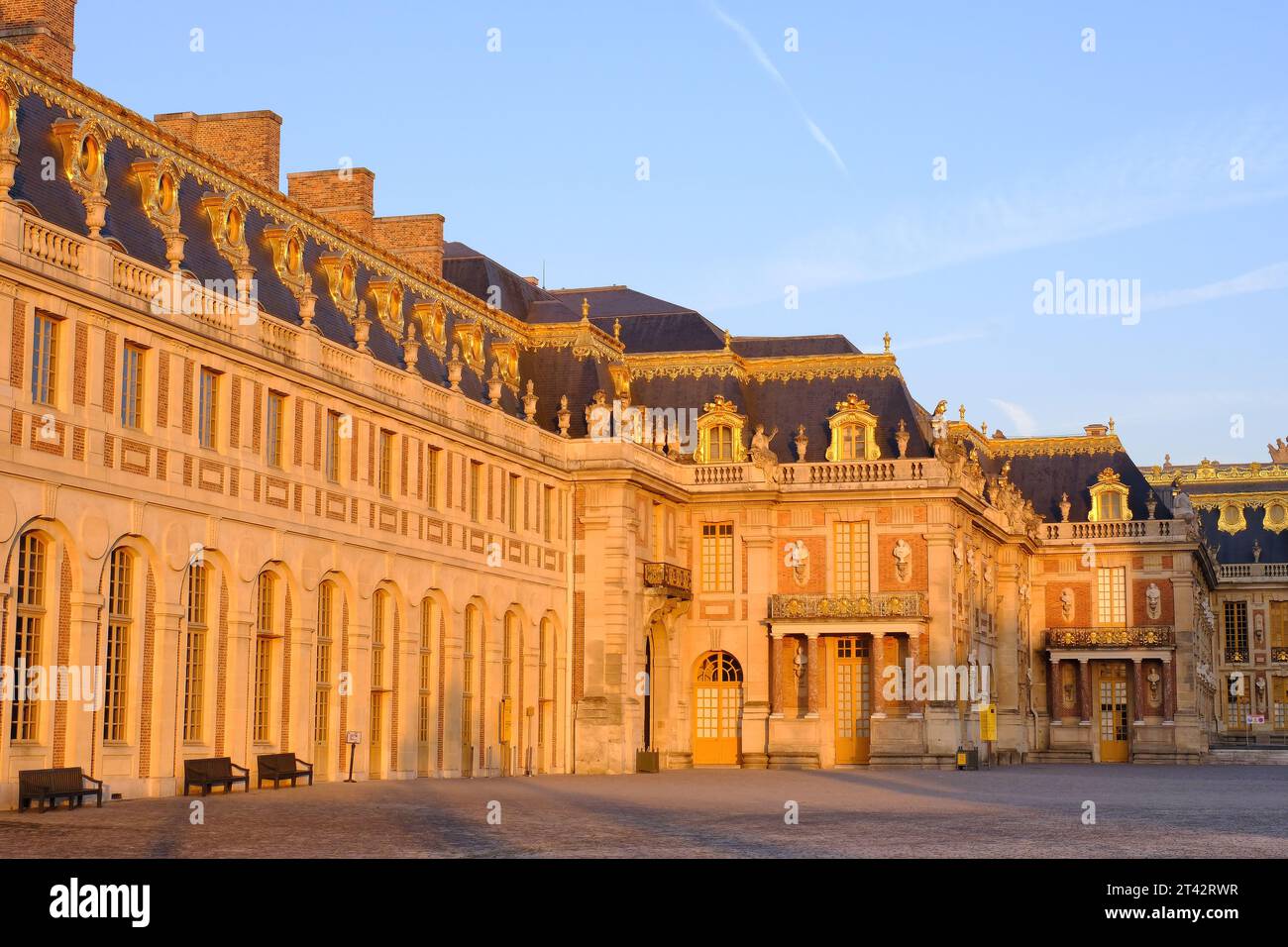 Versailles: Front face (East façade and courtyard) of the palace glowing orange just after sunrise at Versailles, Ile-de-France, France Stock Photo