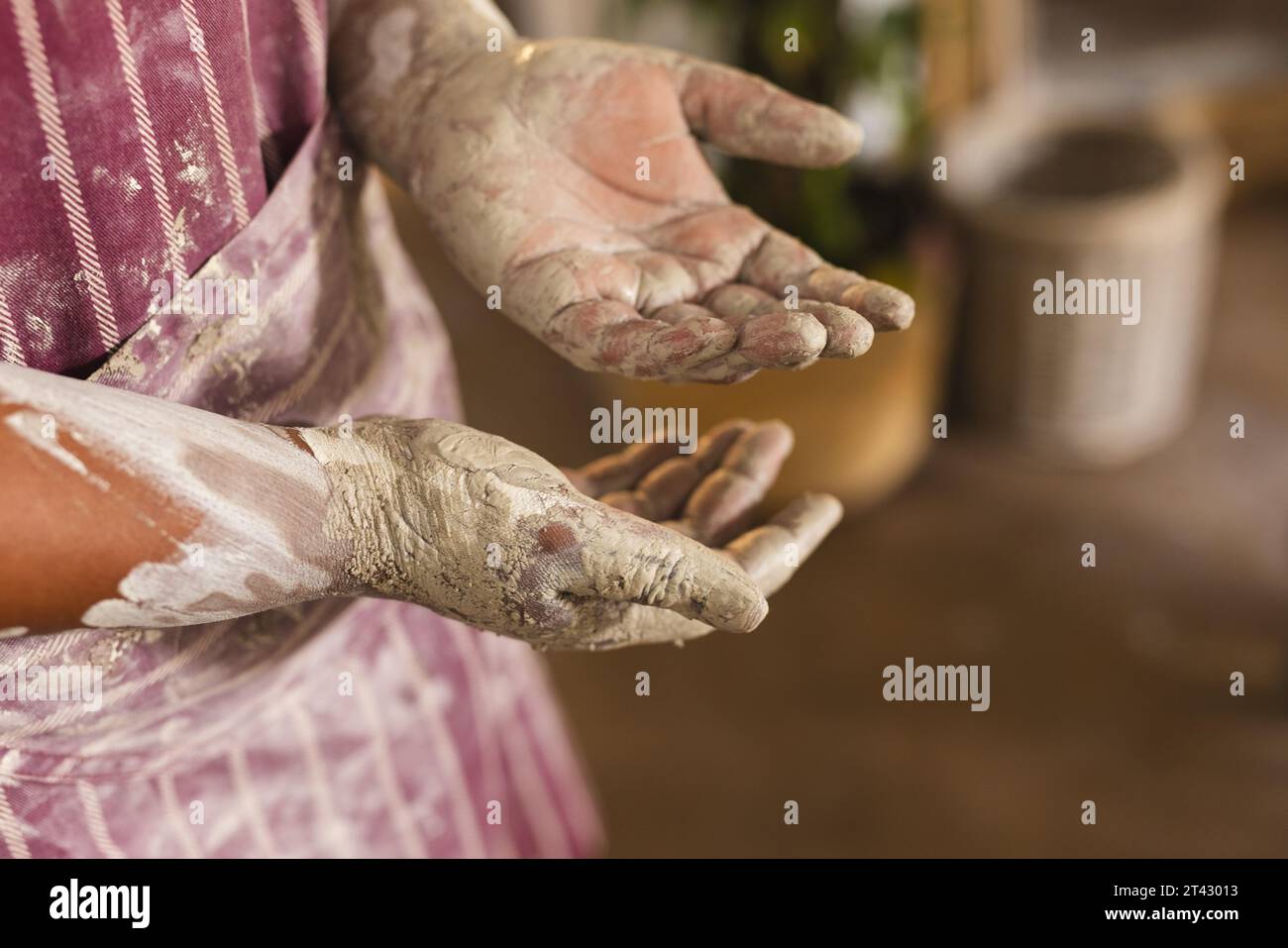 Dirty hands of african american female potter, standing in pottery studio Stock Photo