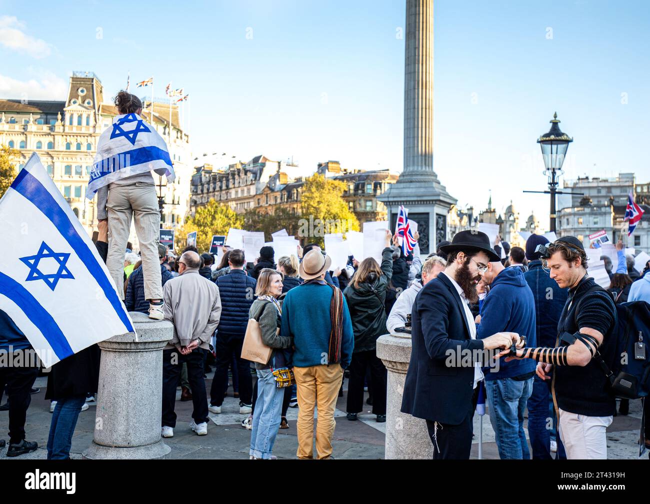 Trafalgar Square London.In the middle of a large demonstration about the Israel/Palestinian conflict an orthodox jew helps a young man ' lay' Tefillin Stock Photo