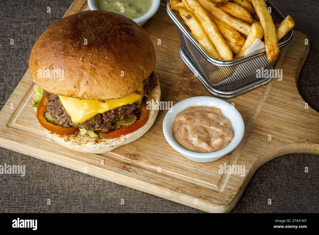 Overhead view of a double cheeseburger with chips and sauces Stock Photo