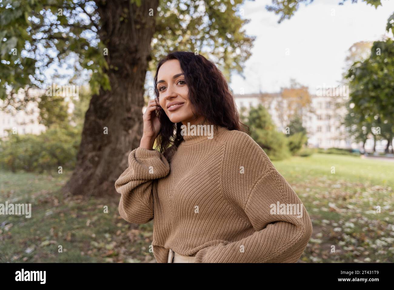 Smiling woman standing in a park on a sunny autumn day, Belarus Stock Photo