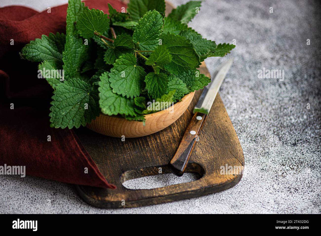 Close-up of a bowl of fresh nettle leaves on a chopping board Stock Photo