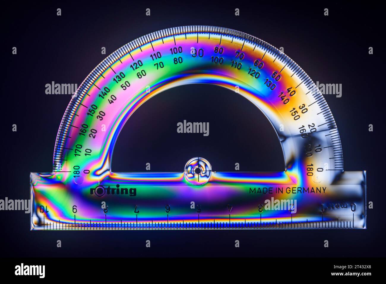 Rotring clear plastic 180 degree protractor and ruler viewed between crossed polarising filters. Stock Photo