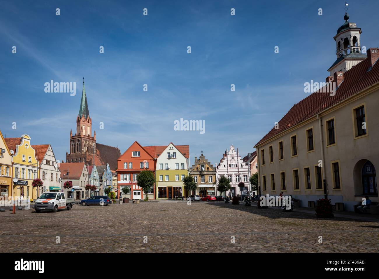 Trzebiatow, Poland - September 18, 2023: Townhall building and colorful tenement houses in historical city center market square. Stock Photo