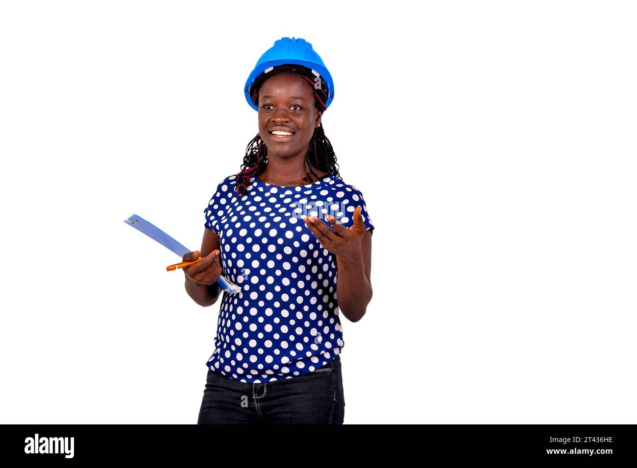 young female construction engineer wearing blue hard hat and holding clipboard while smiling. Stock Photo