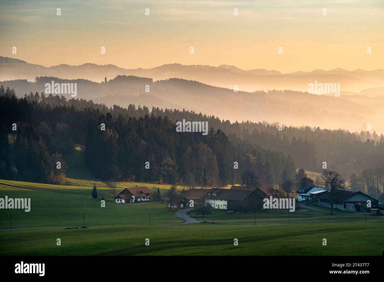 Landscape in the Allgäu in autumn at sunset. Farms and houses in front, mountains in the background. Allgäu, Germany. Image taken from public ground. Stock Photo