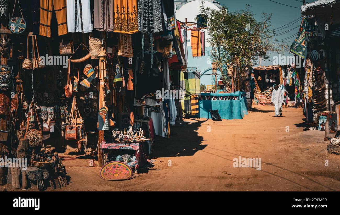 A Nubian market street lined with various stalls selling textiles, spices, and handicrafts Stock Photo
