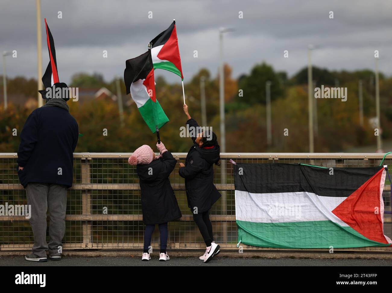 Leicester, Leicestershire, UK. 28th October 2023. Young protesters wave flags during a pro-Palestinian demonstration and banner drop near to the base of UAV Tactical Systems. UAV Tactical Systems is an Israeli-French company manufacturing drones sold to the British army, Israel and international arms markets. Credit Darren Staples/Alamy Live News. Stock Photo