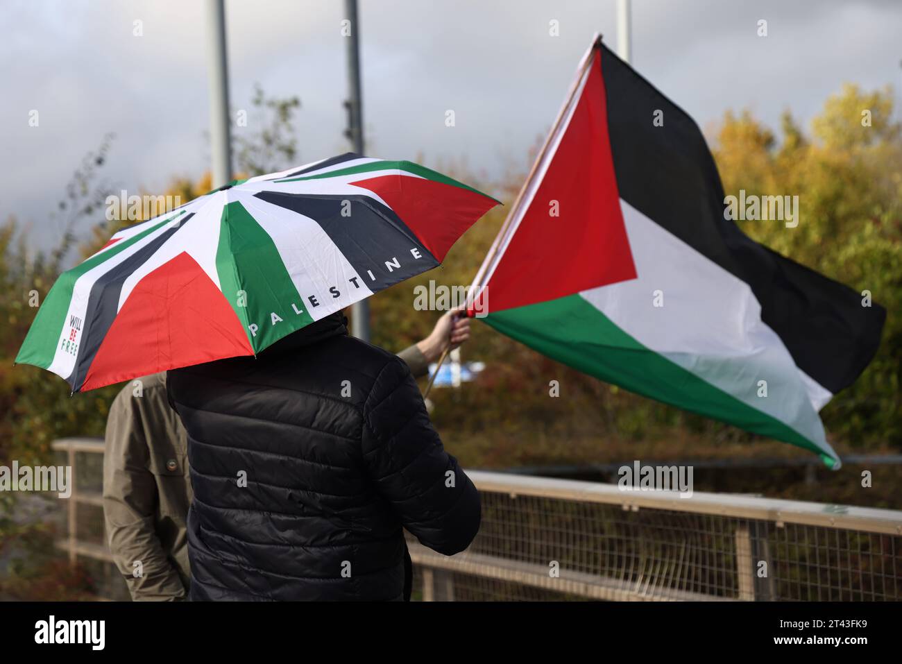 Leicester, Leicestershire, UK. 28th October 2023. Protesters wave flags during a pro-Palestinian demonstration and banner drop near to the base of UAV Tactical Systems. UAV Tactical Systems is an Israeli-French company manufacturing drones sold to the British army, Israel and international arms markets. Credit Darren Staples/Alamy Live News. Stock Photo