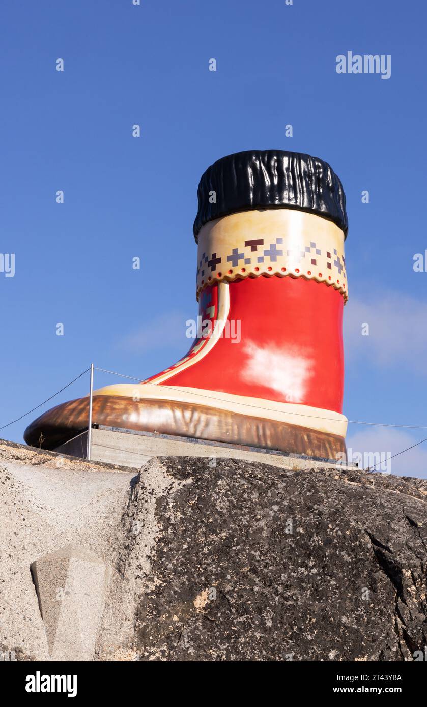 Statue of a large red inuit boot about 5 metres tall, against a blue sky; Qaqortog, Greenland Arctic Stock Photo