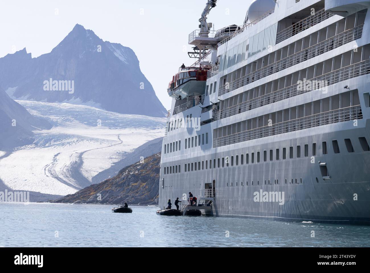 Arctic cruise - passengers returning to the Silversea ship Silver Cloud cruise ship after a zodiac tour; Skjoldungen, Greenland. Arctic Travel. Stock Photo