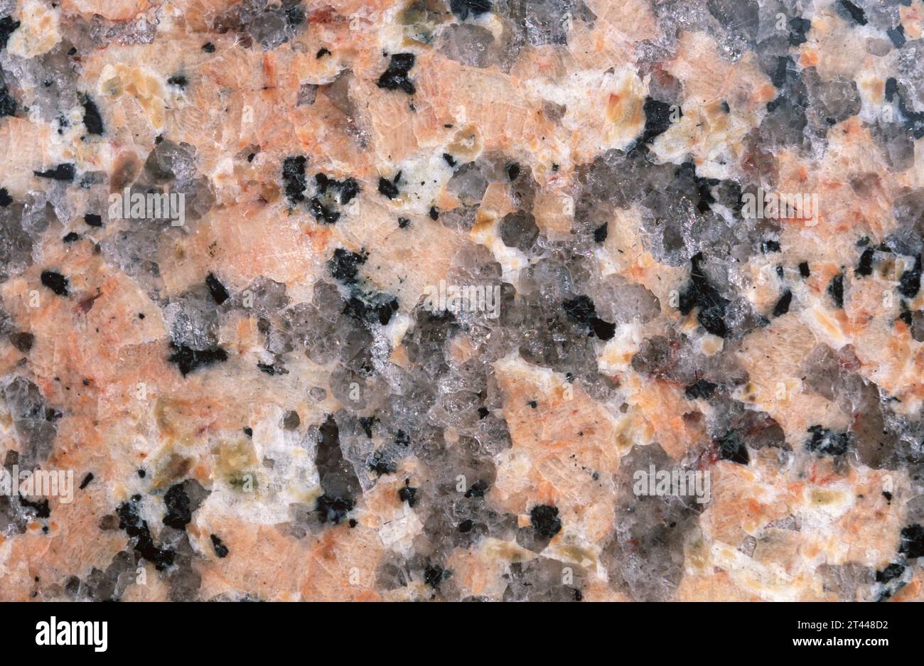 Pink granite. Granite is an igneous intrusive rock with holocrystalline texture. Polished surface. Stock Photo