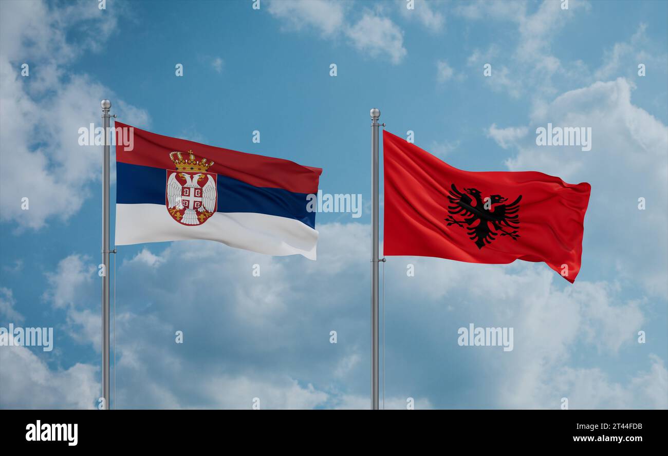 Serbia and Albania flags waving together in the wind on blue cloudy sky ...
