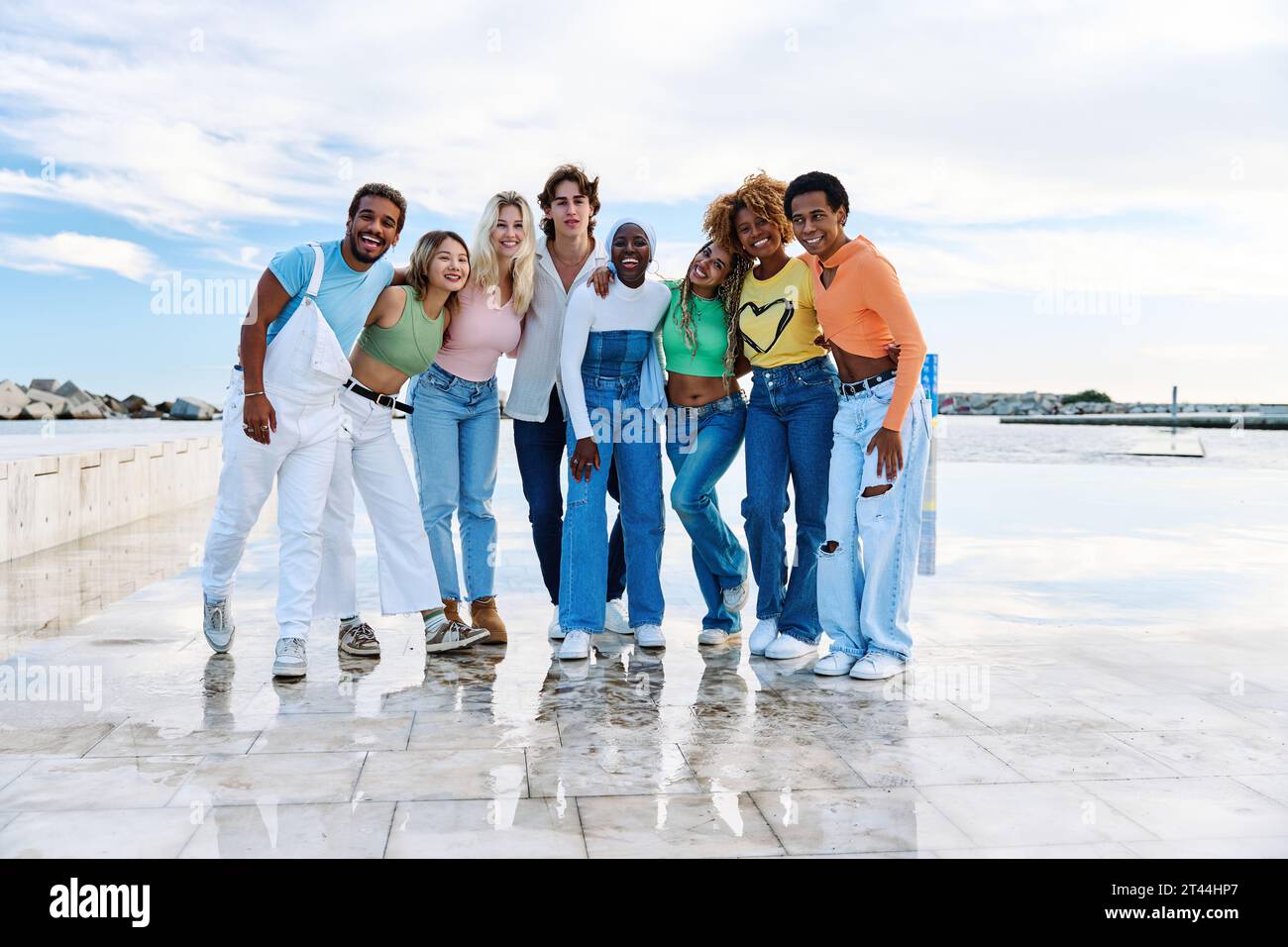 Group of multi-ethnic friends standing together next to the sea Stock Photo