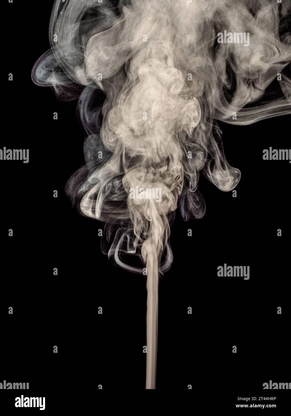 A thin stream of white smoke curls and rising up isolated on a black background Stock Photo