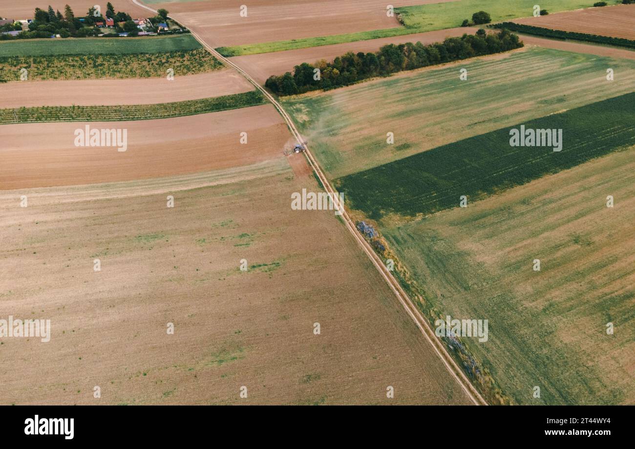 Drone view down on agriculture crop land with wheat fields Vineyards and Tractor Stock Photo