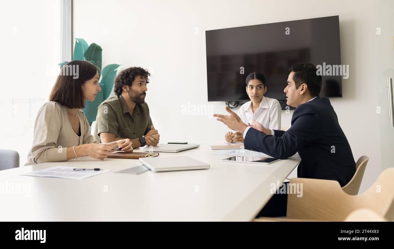 Serious diverse business colleagues discussing work on project Stock Photo