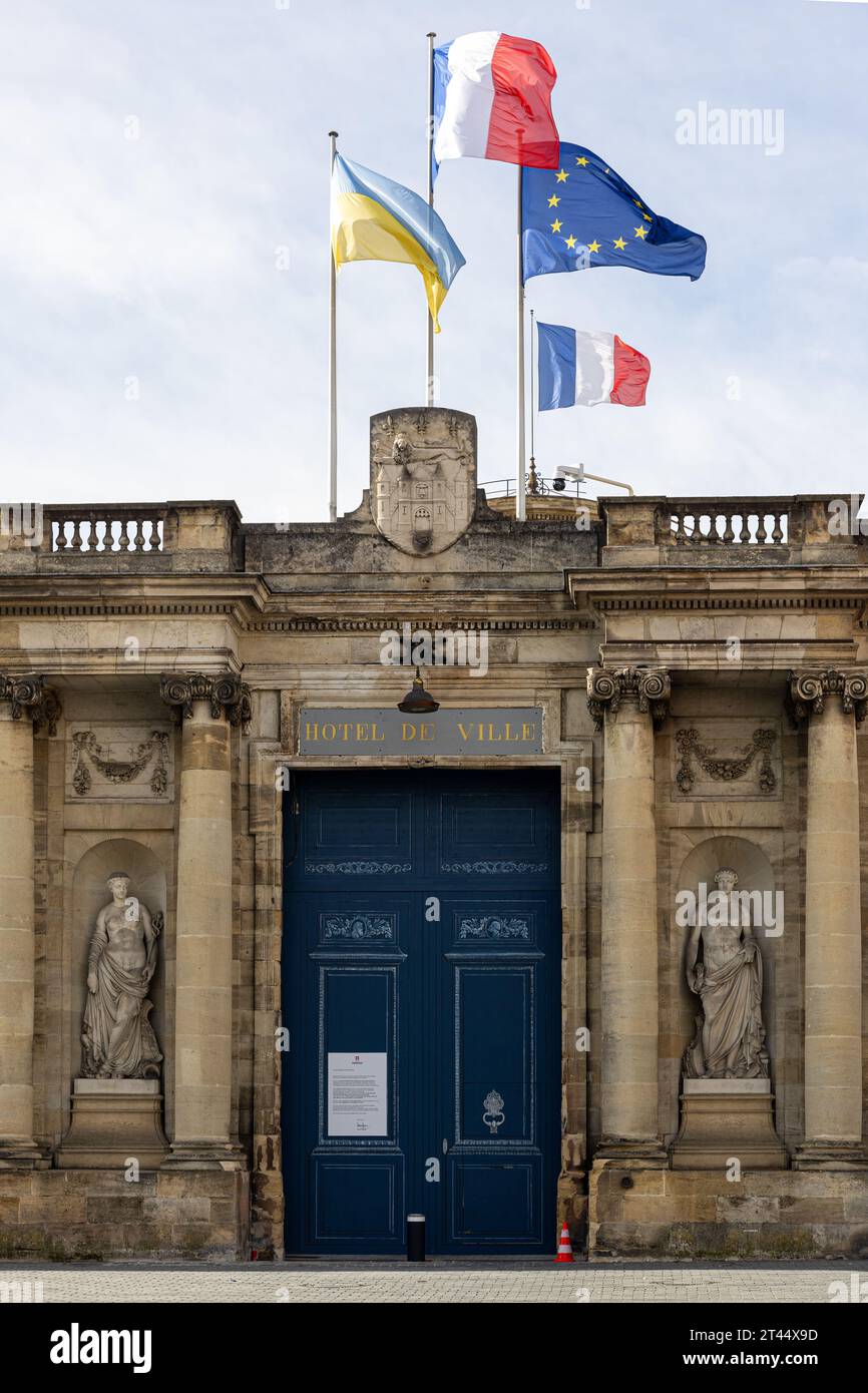 Main entrance of Palais Rohan, showing front door, satues and floating flags Bordeaux, France Stock Photo