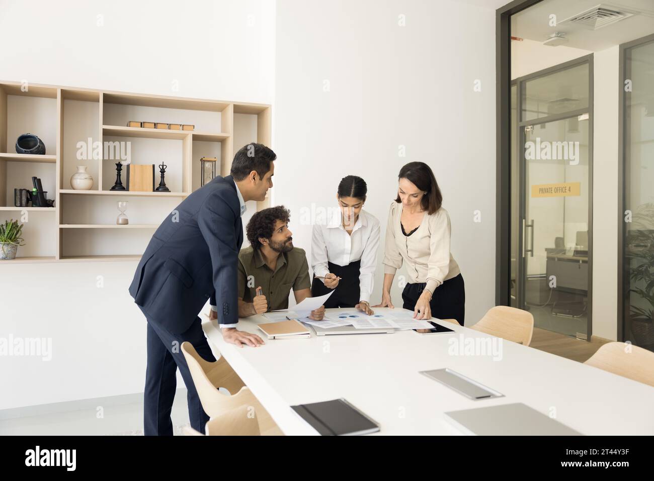 Diverse business colleagues working on project together Stock Photo