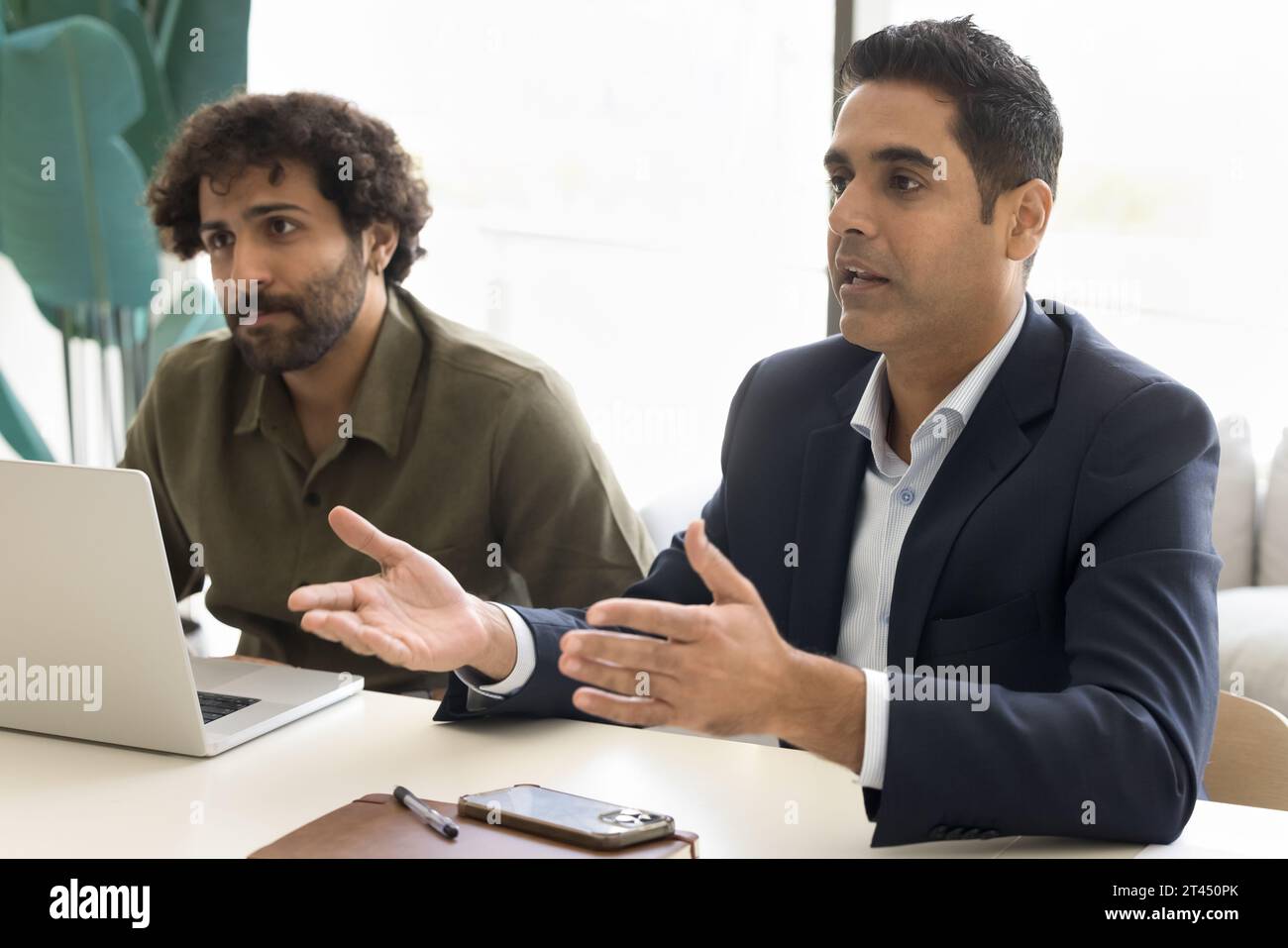 Serious Indian businessman in formal jacket talking partners Stock Photo