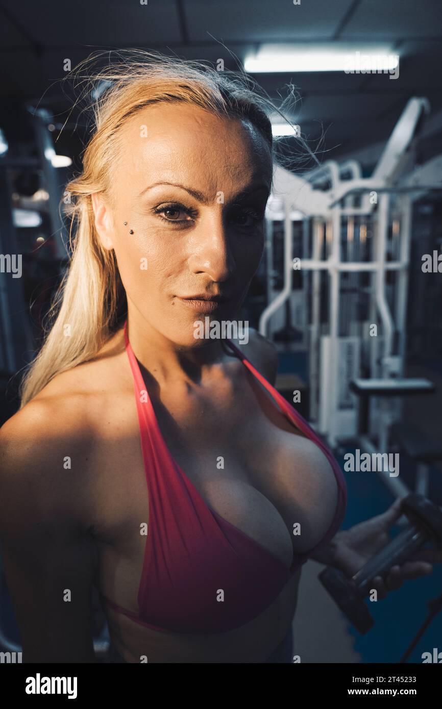Sexy lady fitness gym girl influencer in workout clothes with attractive  body and blonde hair in fitness center Stock Photo