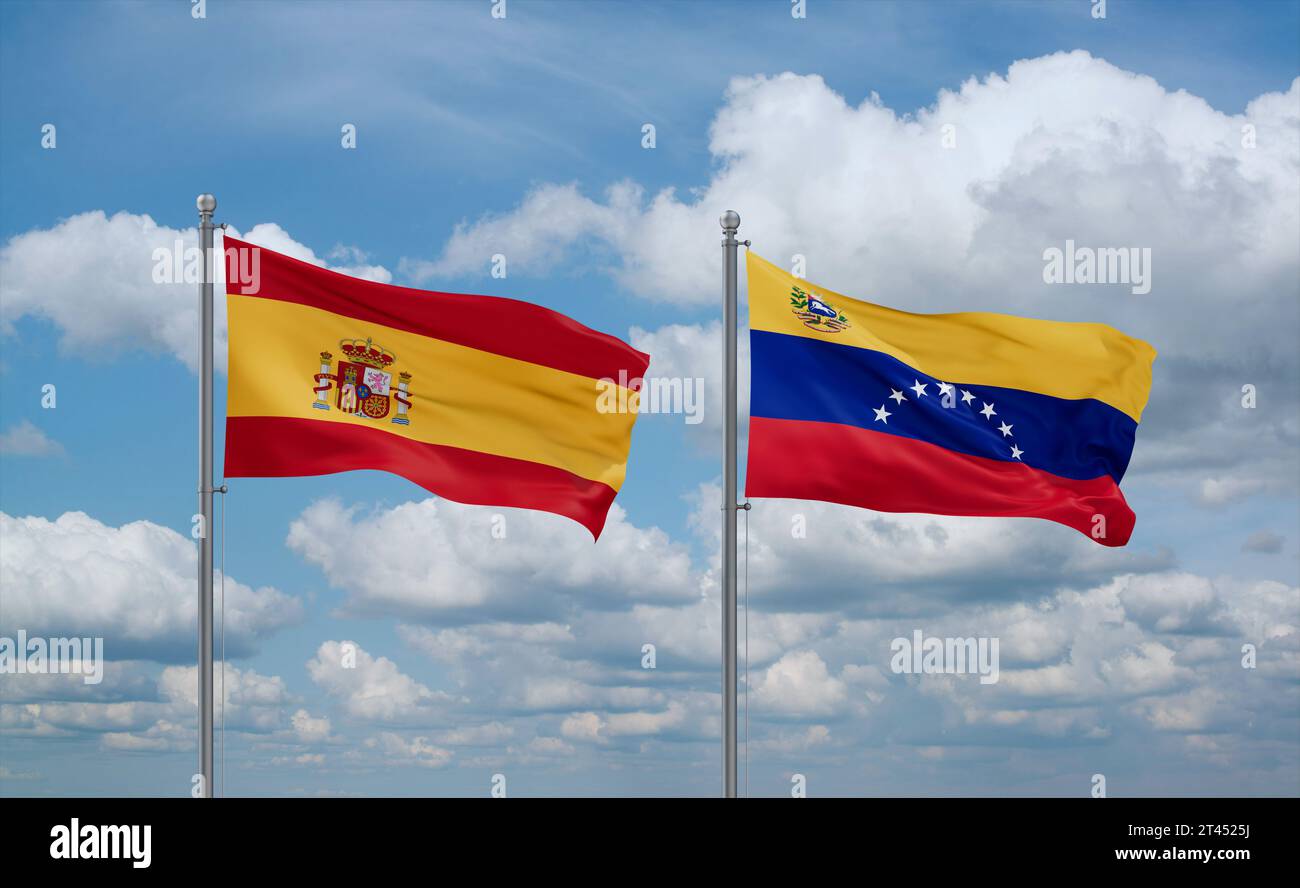 Venezuela and Spain flags waving together in the wind on blue cloudy ...