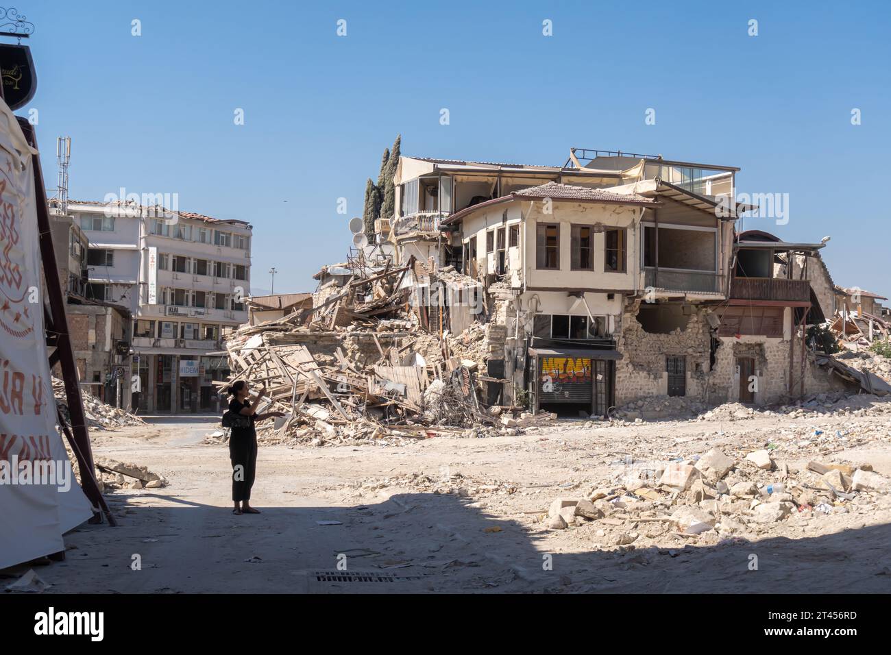 A qoman taking picture of historic Ottoman houses in Merkez district,  central Antakya Turkey severely hit by Earthquake in 2023 Stock Photo
