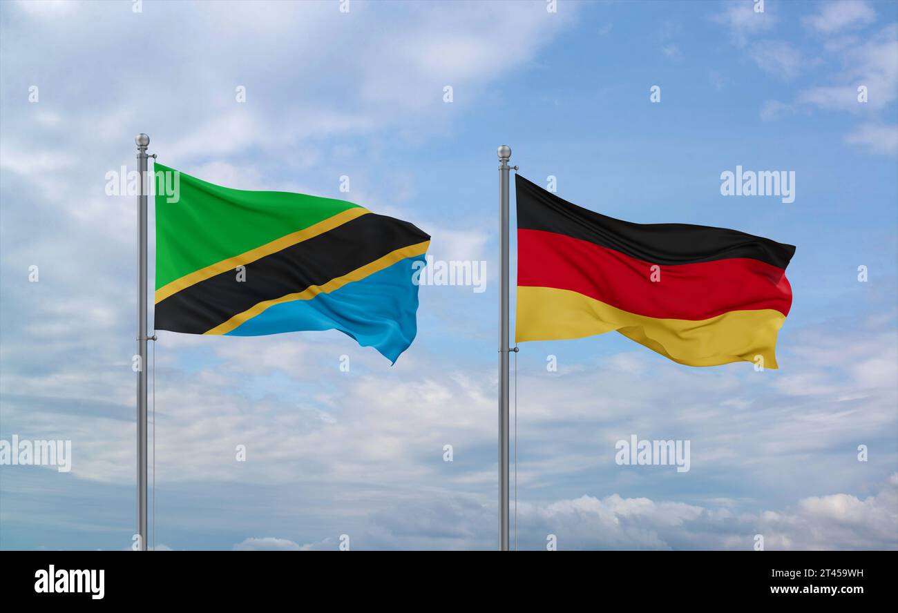 Germany and Tanzania flags waving together on blue cloudy sky, two ...