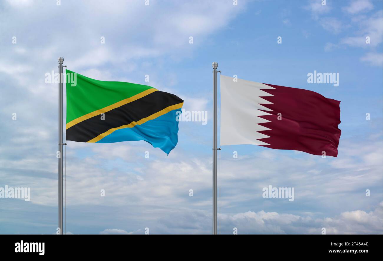 Qatar and Tanzania flags waving together in the wind on blue cloudy sky ...