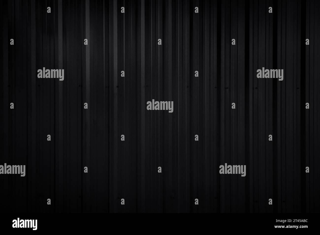 Front view of dark gray, almost black, corrugated galvanized metal wall