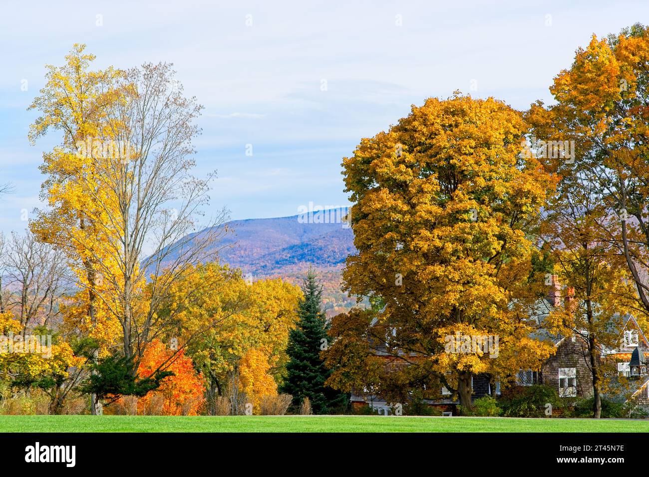 Bright autumn trees shroud colonial style house in Bennington Vermont  with colorful Taconic mountains behind — Bennington, Vermont, October 2023 Stock Photo