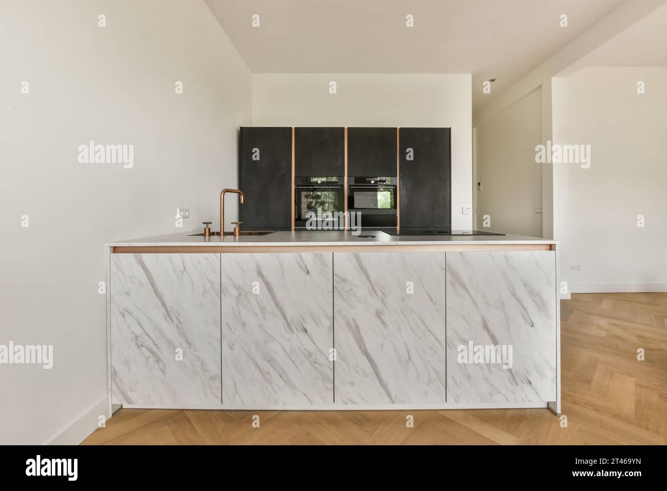 a kitchen with white marble countertops and wooden flooring in the room ...