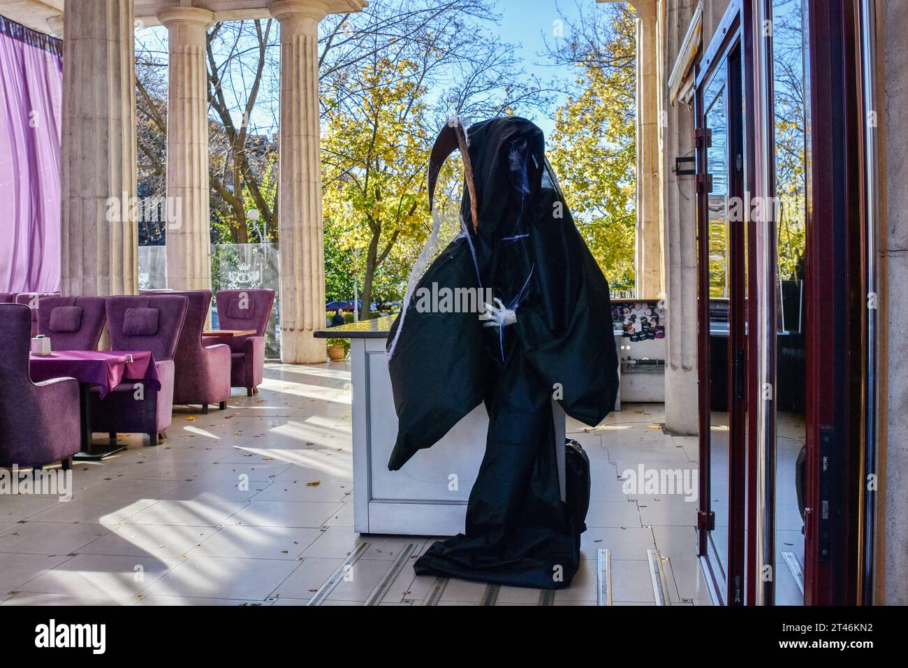 A Halloween decoration (statue of Death) placed at the café entrance in Zaporizhzhia. Halloween of Celtic origin came to Ukraine after the collapse of the Soviet Union. From that time the Ukrainians took over the tradition from other countries to dress in creepy costumes, to cut out the main attribute of this holiday - the pumpkin and to collect the candies among the neighbors. The modern Orthodox Church is still condemning this holiday, but every year in Ukraine are more and more young people who aren't against “going to the side of the evil” for one night. Stock Photo