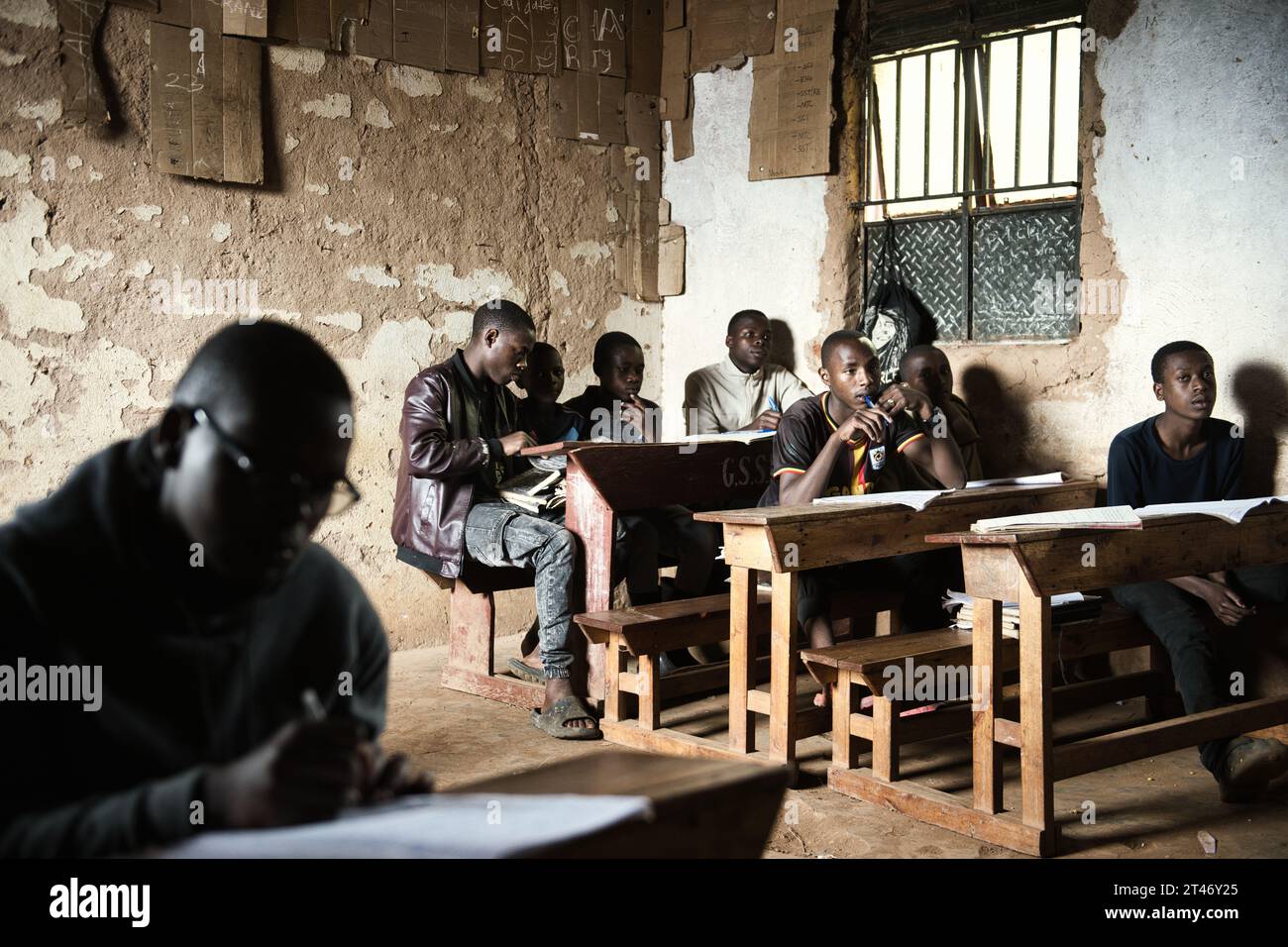 Classroom of boys and girls in a rural school in Uganda, study for their end of term exams in basic surroundings Stock Photo