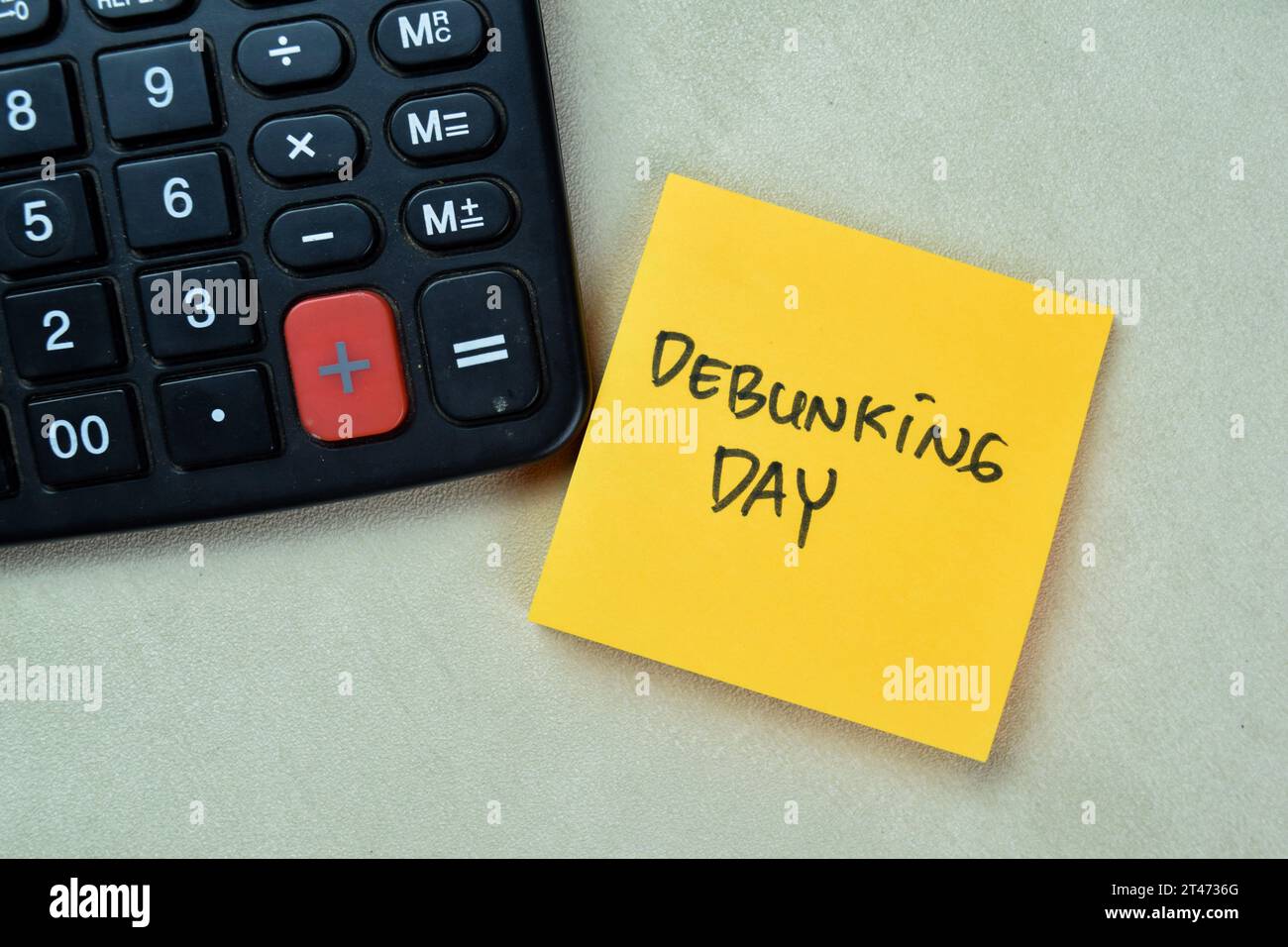 Concept of Debunking Day write on sticky notes isolated on Wooden Table. Stock Photo