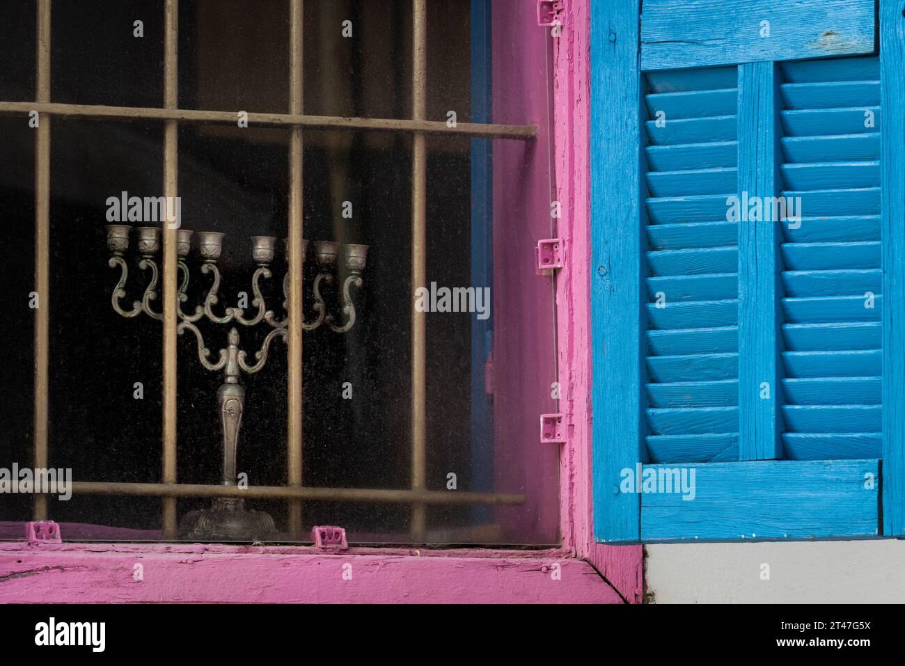 An unlit, silver Hanukkah menora stands idle during the daytime of the