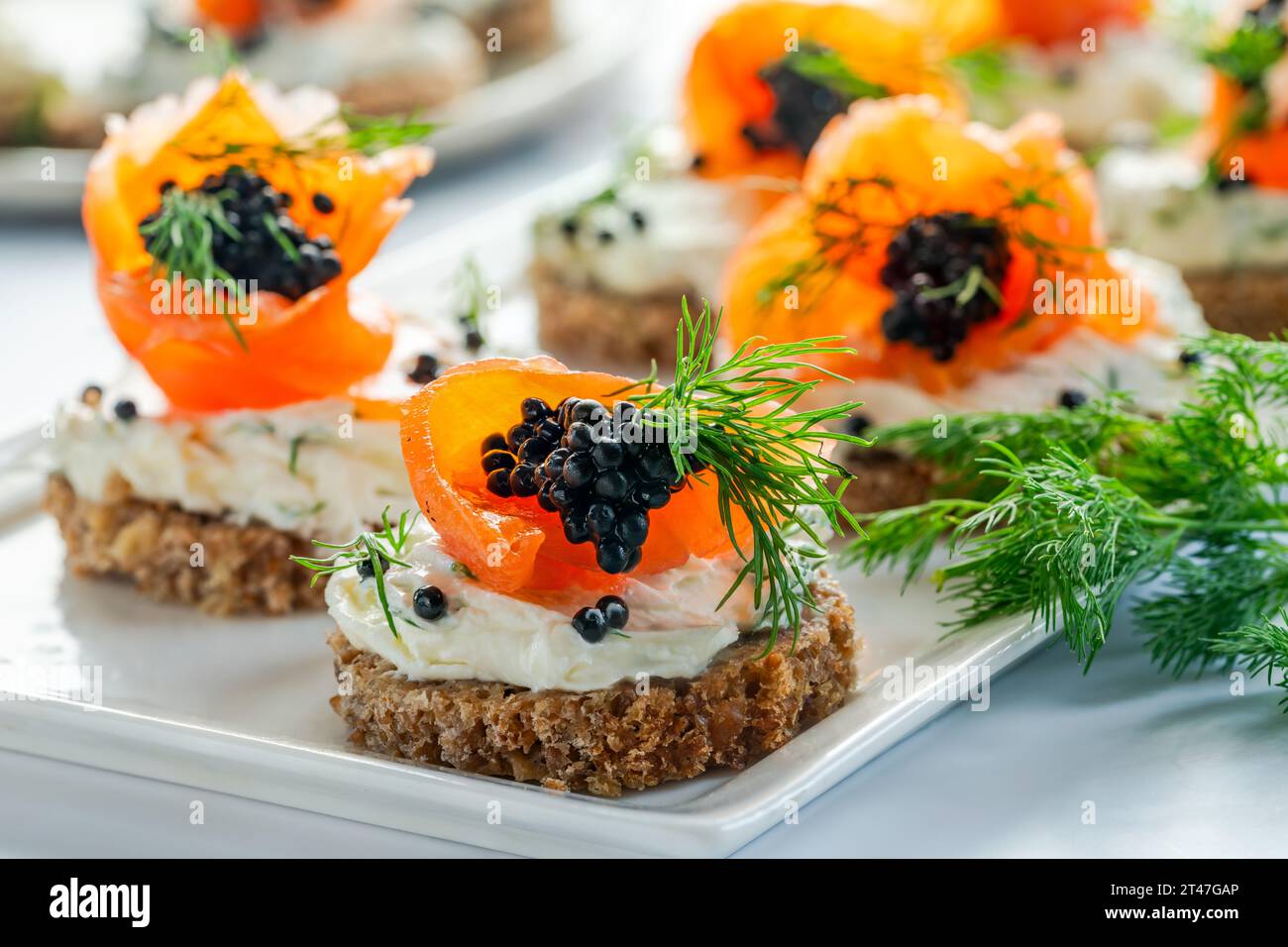 Cocktail canapes with smoked salmon, cream cheese and caviar on rye ...